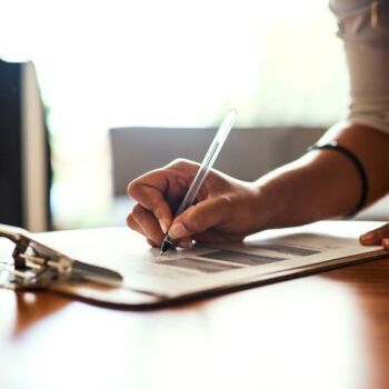 Person writing on form